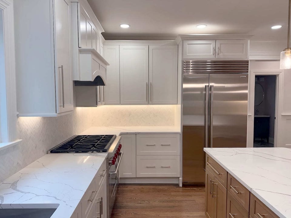 White kitchen cabinetry with marble-look countertops and deep sink in Ridgewood by Fairmount Heights Homes