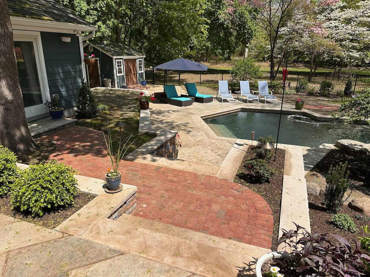 Poolside patio and red brick walkway installation in Ridgewood, NJ by Fairmount Heights Homes.