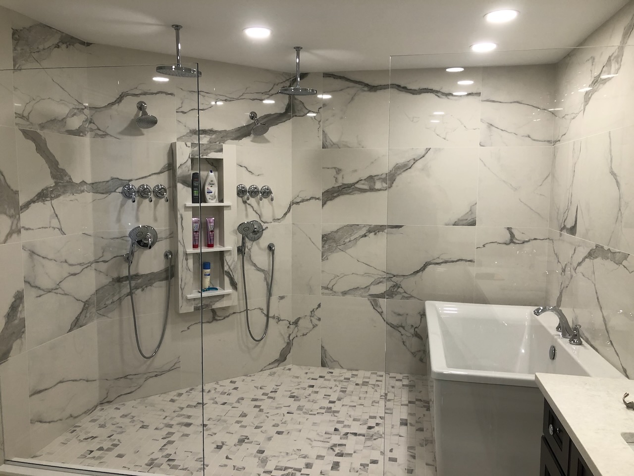Luxury bathroom with double rain showerheads and freestanding tub in a Ridgewood, NJ custom home by Fairmount Heights Homes.