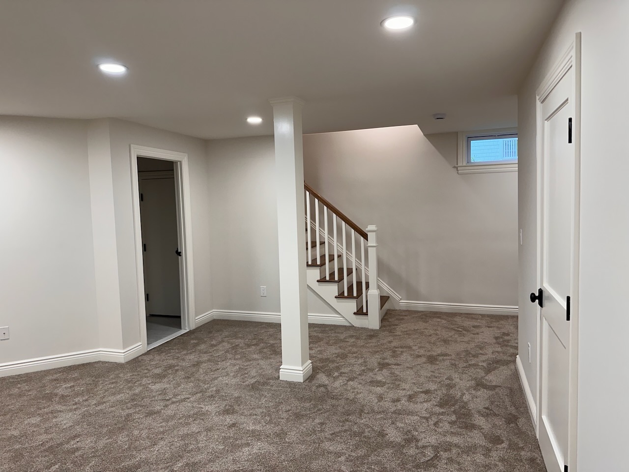 Carpeted basement with stairway access in a Ridgewood, NJ custom home by Fairmount Heights Homes