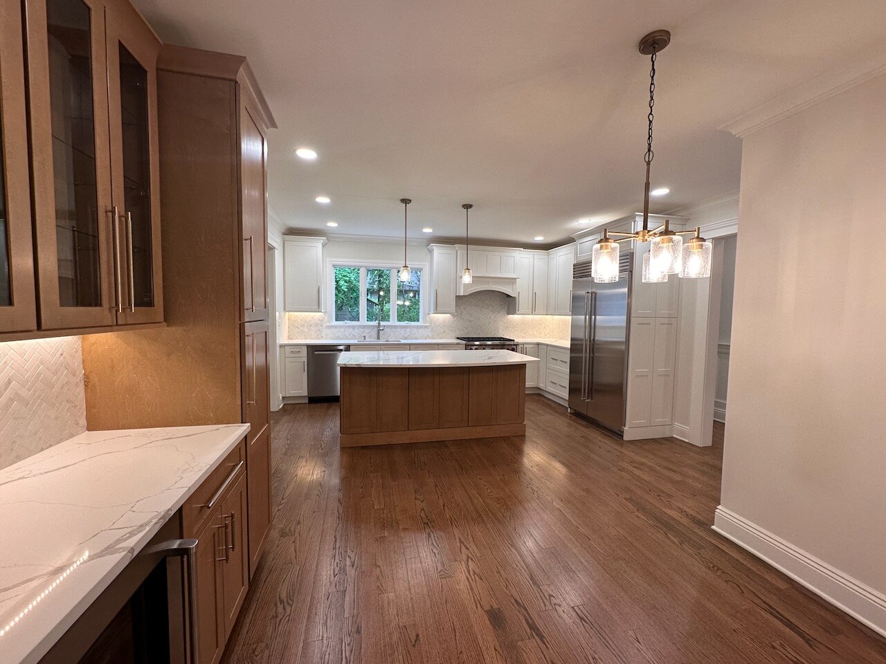 Spacious Ridgewood kitchen with center island and modern pendant lighting by Fairmount Heights Homes.