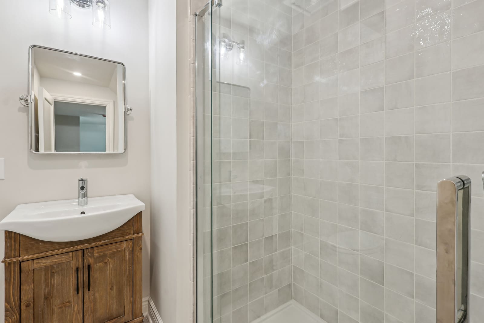 Bathroom in Ridgewood, NJ with tiled shower and wood vanity