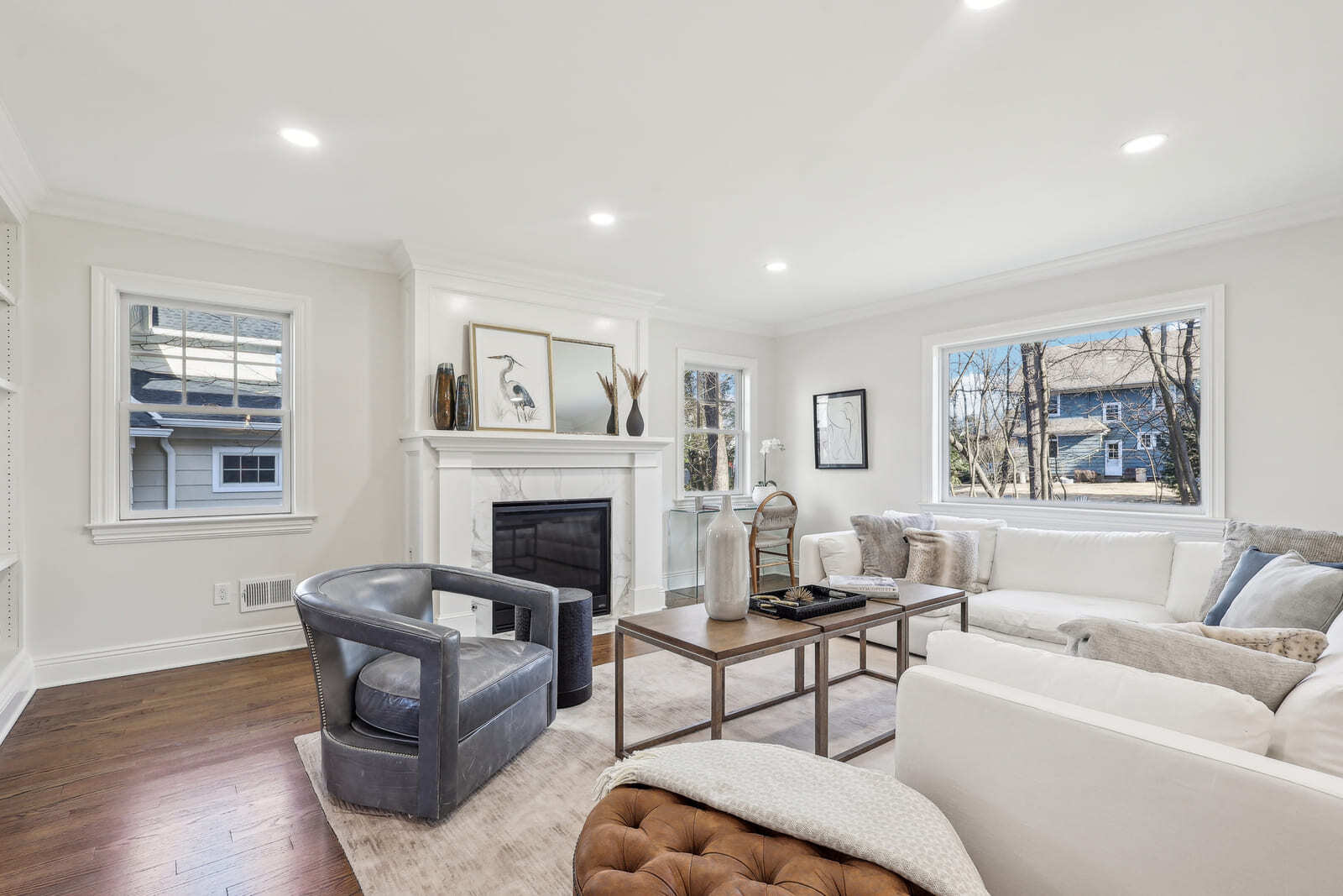 Bright living room in Ridgewood, NJ with marble fireplace, large windows, and neutral seating